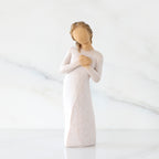 Front view: Standing figure in cream dress with hands to heart in empathetic gesture