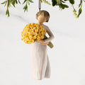 Figure in cream dress, holding large bouquet of yellow roses. Hook and loop affixed to figure's head