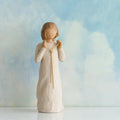 Willow Tree Truly Golden, 5"h hand-painted standing resin figure in cream dress, holding a knotted, long gold chain between her hands, in front of dusty blue painting