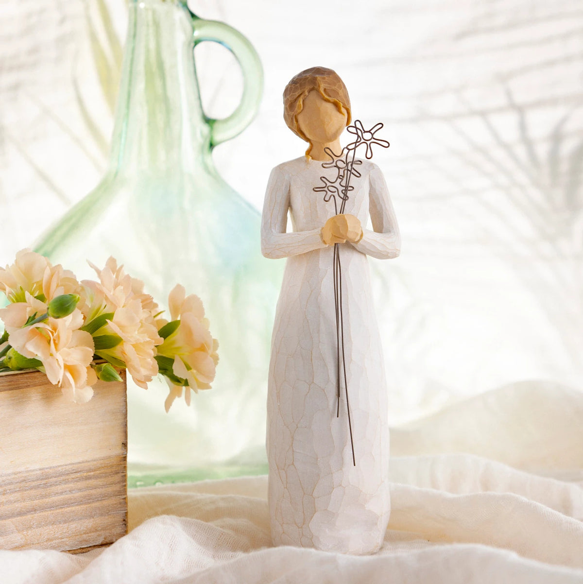 Willow Tree Grateful, 9”h hand-painted standing resin figure in cream dress, holding three wire flowers with long stems, on table with florals