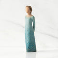 Front/left view: Lighter-skin figure, arms clasped behind back, hair and deep blue ombré garment dotted with gold leaf