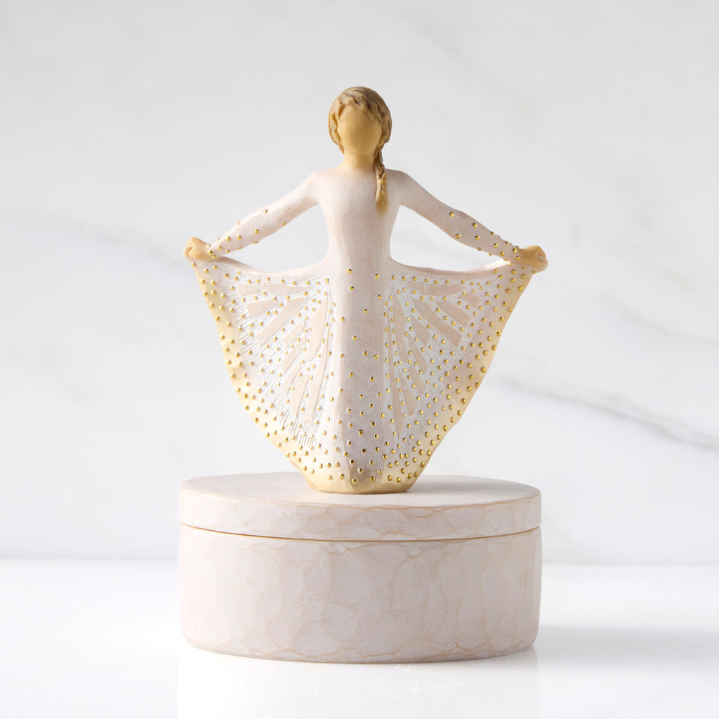 Front view: oval resin box, with 3-D figure in cream and gold carved dress atop lid