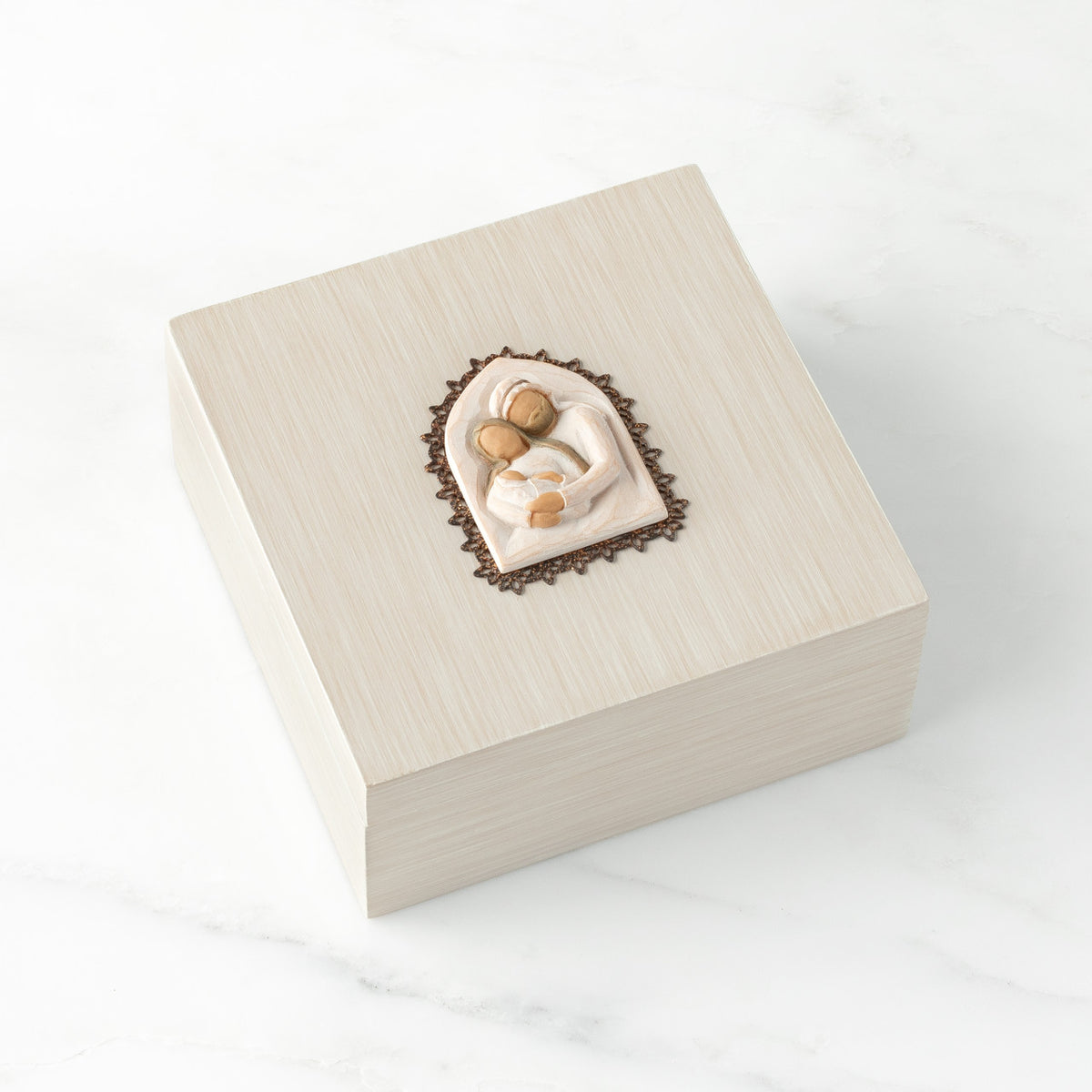 Front view: hand-painted cream square wood box with hinged lid, metal-edged bas-relief carving of Holy Family affixed to lid