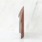 Brown figurine standing up against white background