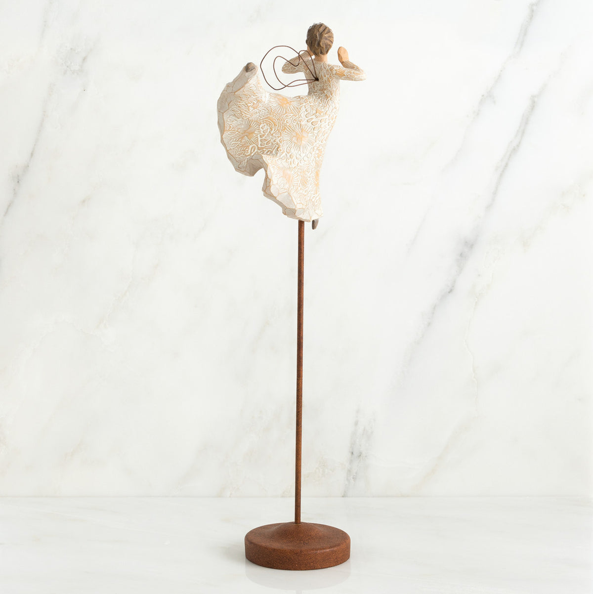 Back view of brunette angel figurine in white dress with arms up, standing on large wooden stand