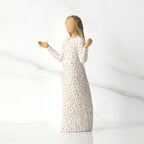 Side view of brunette girl figurine in white dress with gold dots holding her hands up