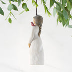 Left side of figure in cream dress with cardinal red bird perched on shoulder, hook & loop in head