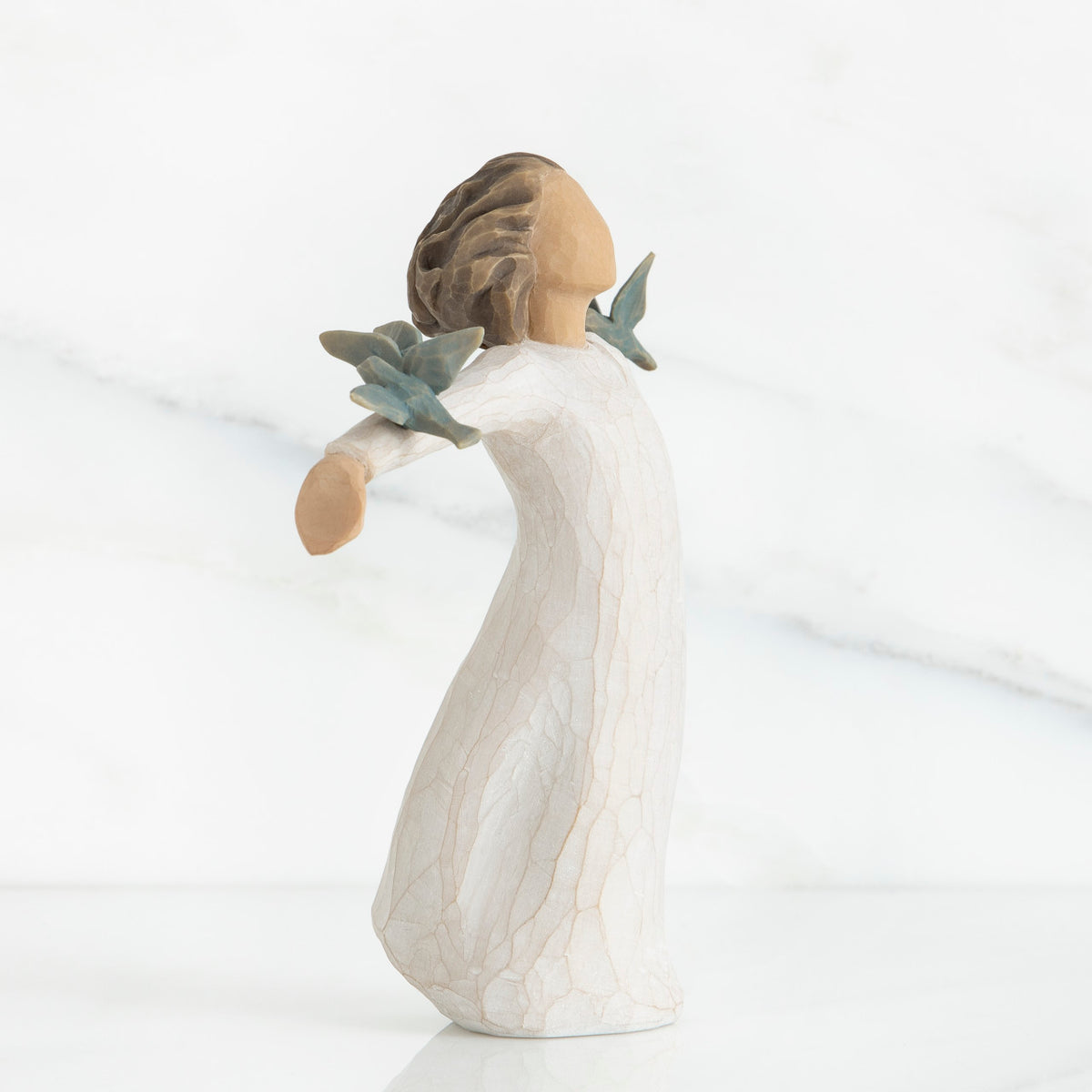Young brunette girl figurine in white dress arms spread looking up with two blue birds on her arms