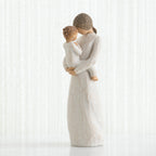 Mother figurine in white dress with brunette hair holding baby in white