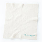Overview of white towel with 'so loved, so very loved' in light blue in the right corner
