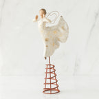 Angel figurine standing on red stand wearing white dress