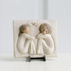 Small cream rectangle plaque with two girl figurines carved in sitting down facing one another
