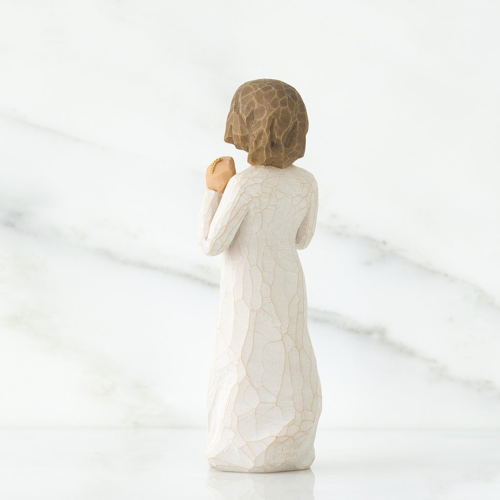 Back view of brunette girl figurine in white dress