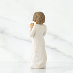 Back view of brunette girl figurine in white dress