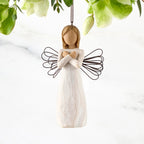 Figure in cream dress with wire wings and arms crossed in front of chest, ornament loop fixed to figure's head