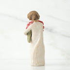 Back view of brunette woman figurine in white dress holding flowers