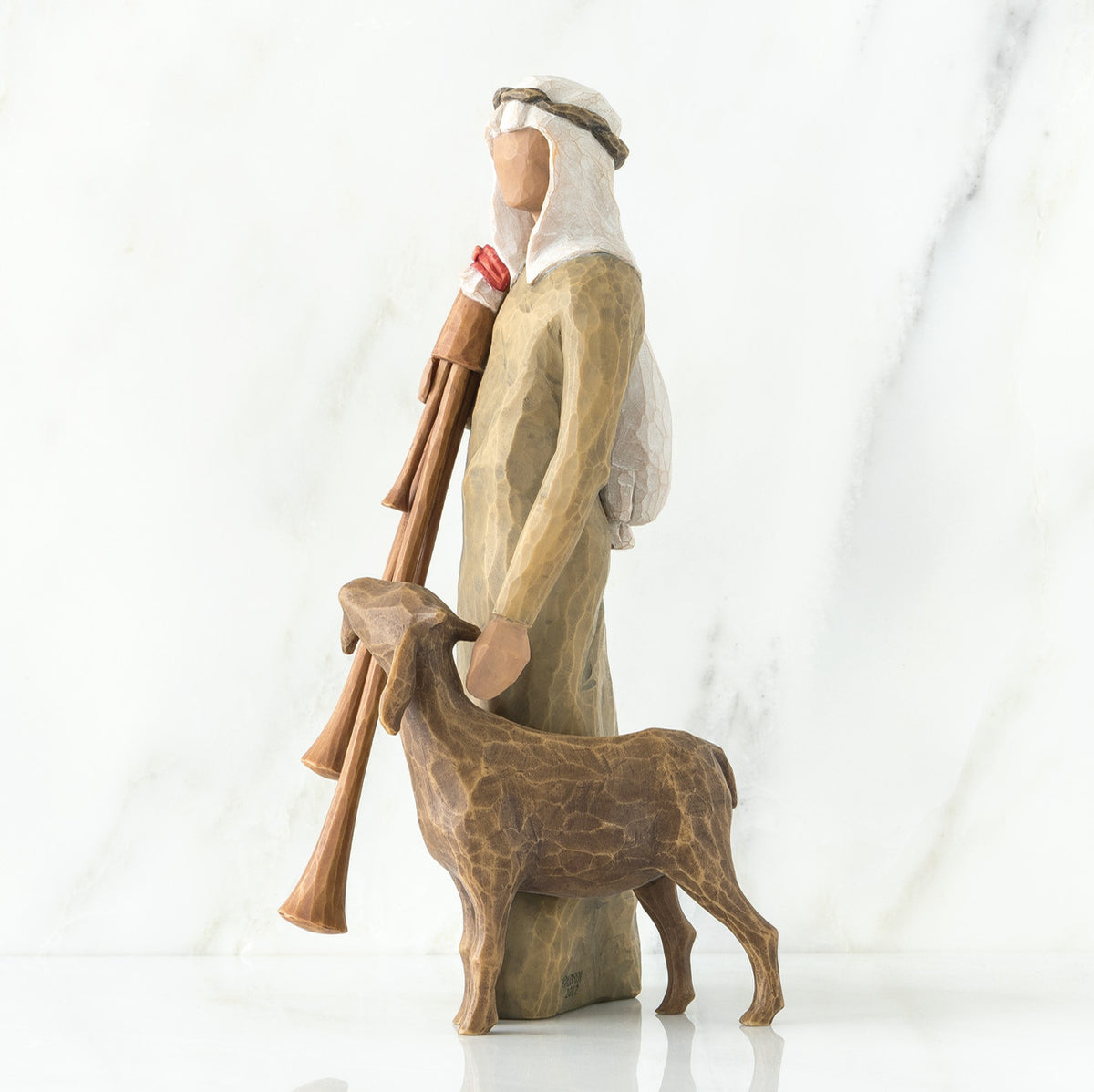 Wiseman figurine in brown next to sheep figurine