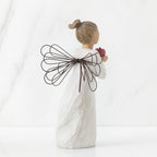 Back view of angel with brown hair in high pony tail leaning forward and holding a red apple up to her face with both hands