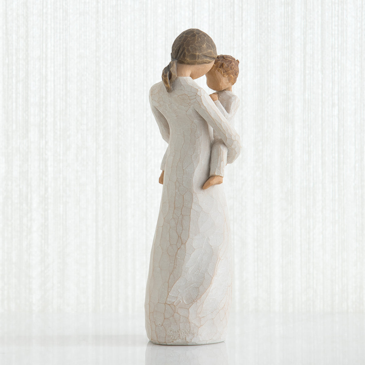 Back view of brunette girl in white dress holding boy figurine