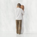 Back view of couple, standing with arms around each other. Woman has lighter skin and hair; man has darker skin and hair.