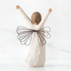 Back view of brunette angel figurine in white dress with brown wire wings