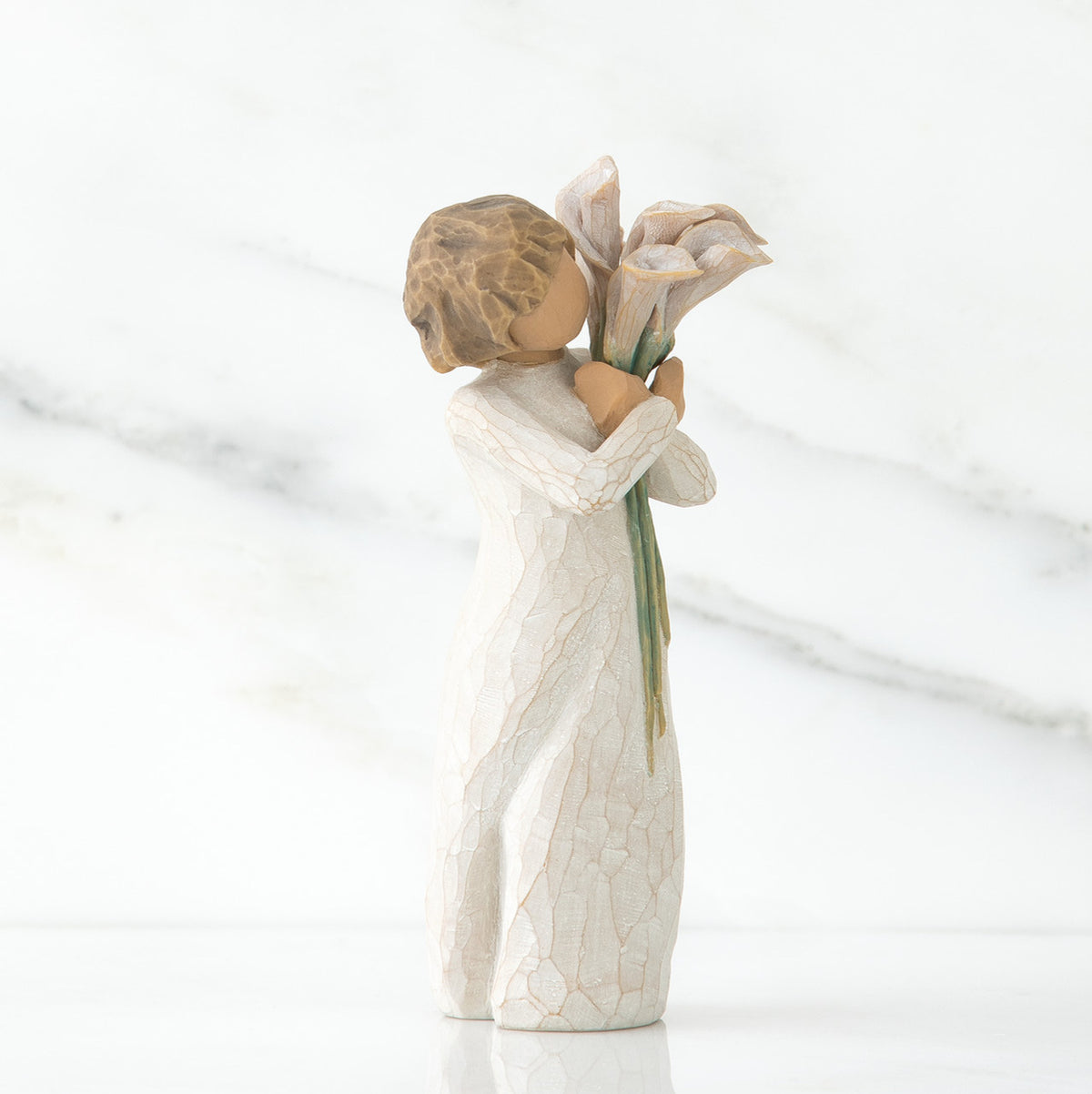 Left side view of lIttle girl with short brown hair holding a cluter of white calla lilies