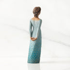 Facing back/right: Darker-skin figure, arms clasped behind back, hair and deep blue ombré garment dotted with gold leaf