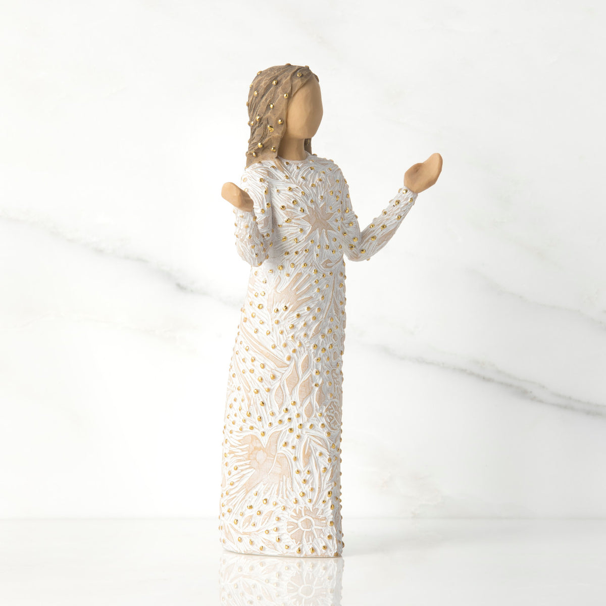 Side view of brunette woman figurine in white dress with gold dots holding her hands up