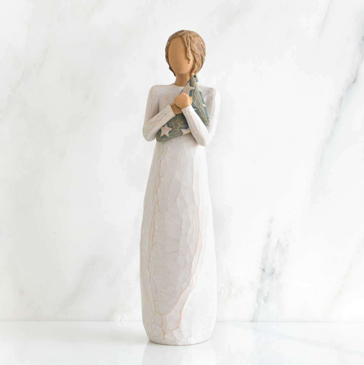Faceless woman figurine standing facing forward wearing white dress holding star print napkin