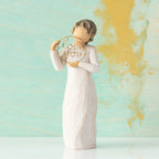 Willow Tree Love you, 5.5”h hand-painted standing resin figure in cream dress, holding gold wire circle with 'love you' inside, in front of mint and gold painting