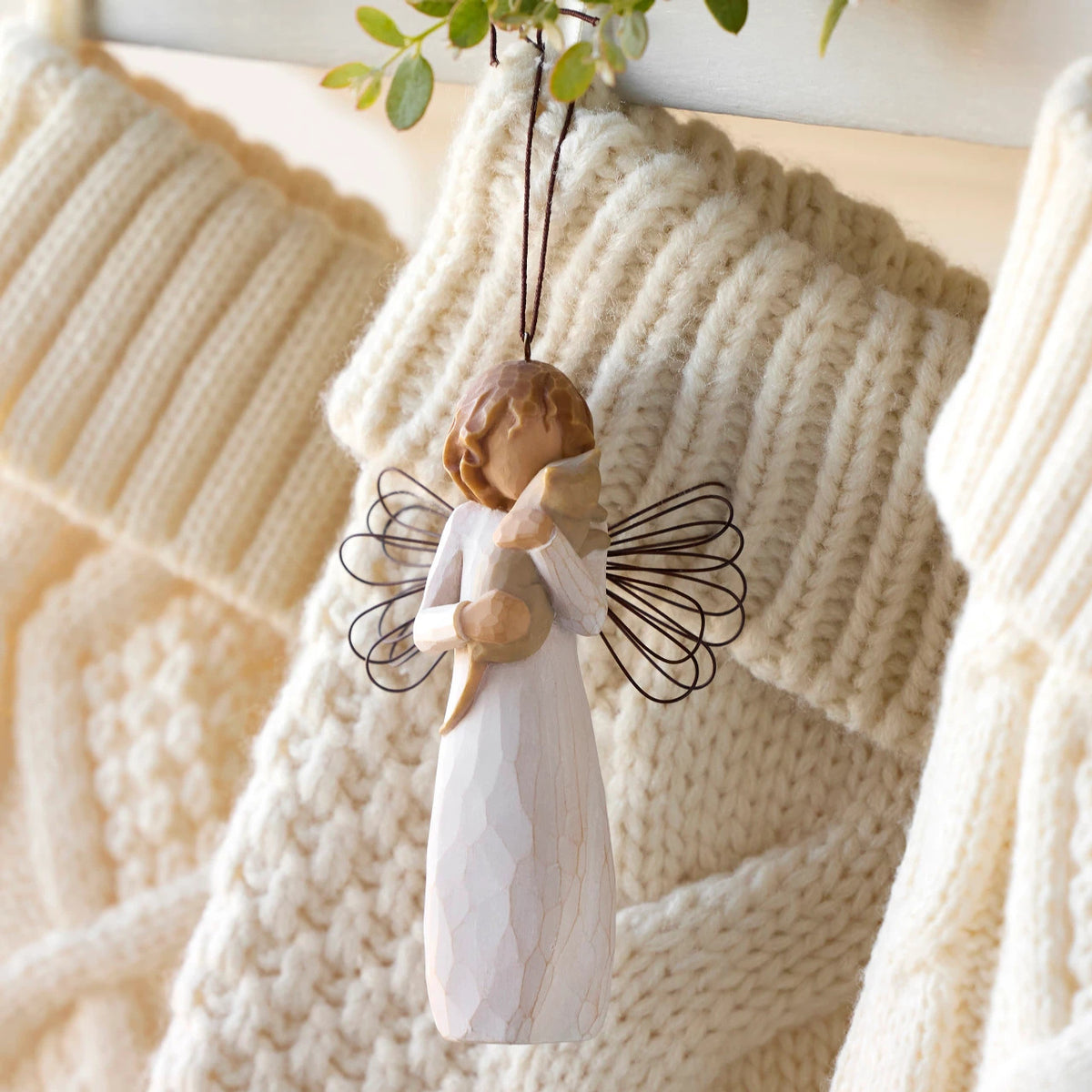 Willow Tree With affection Ornament, 4.5”h hand-painted resin figure in cream dress with wire wings, holding gray cat, brown elastic cord, hanging with cream knitted Christmas stockings