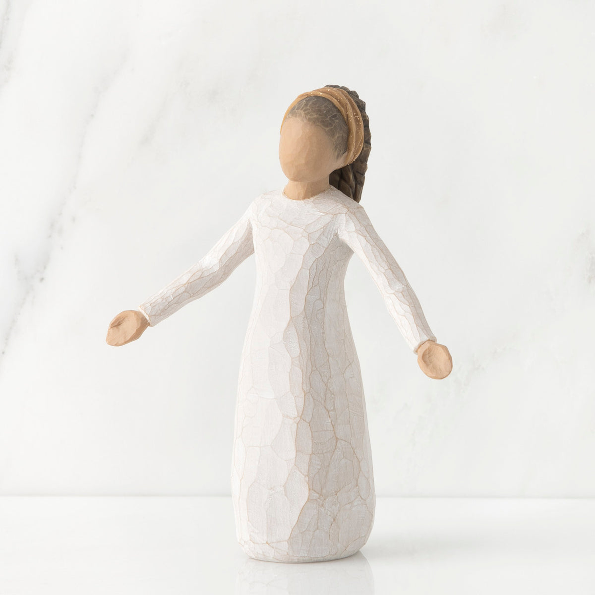Young faceless girl figurine standing wearing all white dress with her arms out