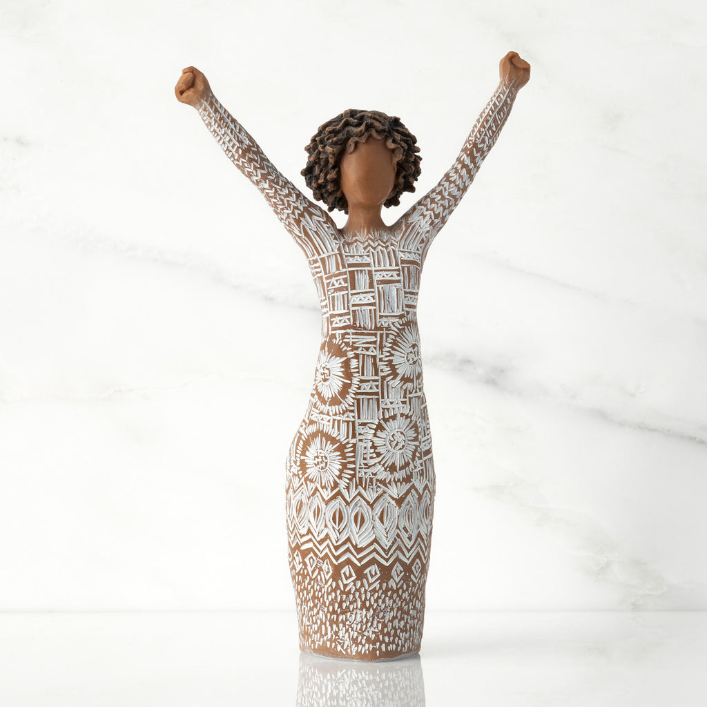 Front view of figure with natural hairstyle, arms raised overhead, dress etched with African textile patterns