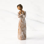 Facing center: Darker-skin figure carved with contrasting pattern of white musical symbols, instruments, dancing forms