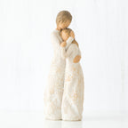 Mother faceless figurine hugging faceless daughter figurine - both standing wearing white dresses