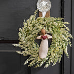 Willow Tree With Love Ornament, 4”h hand-painted resin angel figure with darker hair and skin, in cream dress, wire wings, holding red heart, brown elastic cord, hanging inside spring wreath