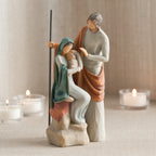 Man figurine standing next to mother figurine in blue holding baby