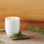 Filled scented candle with unglazed off-white tapered cylinder vessel, sentiment written in gold inside rim, plant-based wax blend, all-cotton wick.